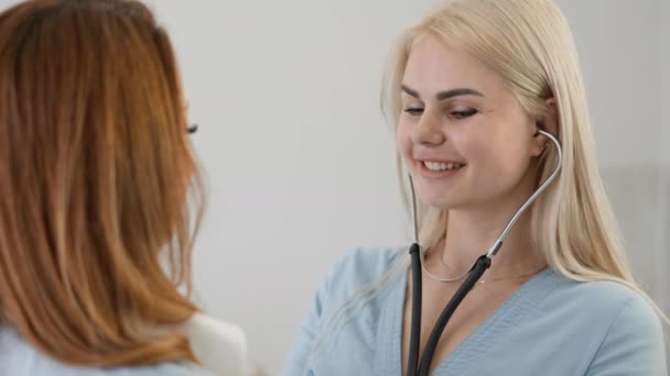 Una Doctora Escucha Una Paciente Con Estetoscopio Una Joven Examen — Vídeo de stock