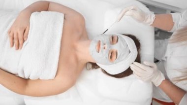 Kadın kaplıcaya gençleştirici yüz maskesi takıyor. Maske cildini nemlendirir, temizler ve besler, tazeler ve canlandırır. Spa 'nın rahatlatıcı atmosferi genel olarak...