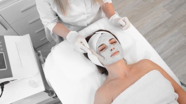 Cosmetologist Executa Tratamento Facial Uma Jovem Mulher Uma Clínica Beleza — Vídeo de Stock