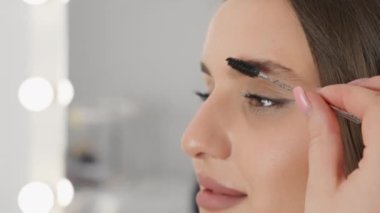 Mükemmel bir fiksasyon ve şekil yaratmak için kaş jölesinin nasıl kullanıldığını gösteren yakın çekim bir video. Güzellik salonundaki güzellik uzmanı yüz bakımı hizmeti veriyor. Yüksek kalite 4k görüntü