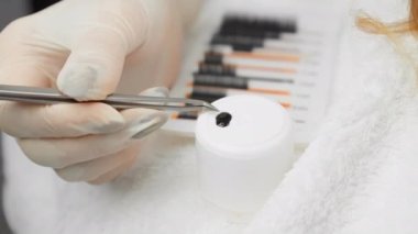 Kirpik dizaynı yapabilen usta kirpik üreticisi, bir kadının görünüşüne zarafet ve cazibe katıyor. Güzellik salonundaki kirpik uzantıları. Güzellik uzmanı cımbızla çalışır.