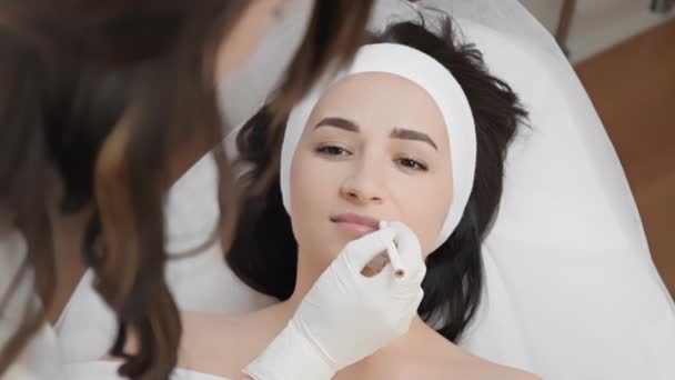 Profesjonalny Kosmetolog Robi Oznaczenia Kobiecej Twarzy Przygotowując Się Wstrzyknięcia Botoksu — Wideo stockowe
