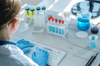 Bir nörolog nörodejeneratif hastalıkları olan hastaların verilerini analiz eder ve tıbbi laboratuardaki bir bilgisayarda durumlarını inceler. Bilim adamı klavyede daktilo, kamera arkasında. Yüksek kalite