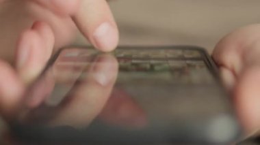 İnternette sohbet etmek ve içeriği taramak için akıllı telefon kullanan bir adamın eli. Bir adam akıllı telefonunu video ve müzik izlemek için kullanır, yakın planda görüntülenir. Yüksek kalite 4k görüntü