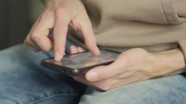 Haberleri ve bilgileri hızlı bir şekilde internetten izlemek için akıllı telefon kullanarak yakın plan çekimde. Adam internetteki fotoğrafları görüntülemek ve düzenlemek için akıllı telefonunu kullanıyor. Yüksek kalite 4k görüntü