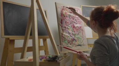 Resimdeki sanatçı eserlerini bir sehpaya çizmeye odaklanıyor ve unutulmaz çizimlere doğru yol açıyor. Bir kişinin duygularını ve kendini ifade etme süreci olarak çizmek. Sanat terapisi. Yüksek