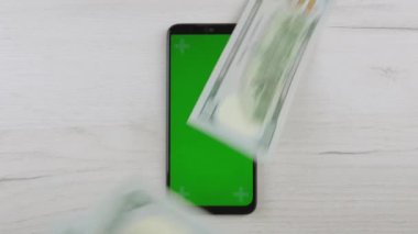 Cep telefonu ödemeleri için bir banka başvurusuna sahip bir akıllı telefonun fotoğrafı, çevrimiçi bankacılığa adanmış projeler ve mobil iletişim yoluyla hizmetler için yapılan ödemeler için yararlıdır. Bir sürü para ve altın.