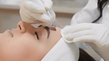 Güzellik salonundaki ultrasonik yüz temizleme dermatolojik terapisi tam bir yüz bakımı sağlar. Güzellik kliniğindeki beyaz eldivenli güzellik uzmanının kozmetik ameliyatındaki bir kadının yakın çekimi.