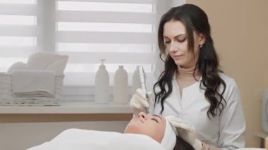Kalifiye bir kozmetolojistin rehberliğinde güzellik salonlarında bulunan cilt tedavisinin yenilikçi bir yöntemi olarak yüz terapisi kısmi. Yenileme ve nemlendirme