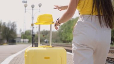 Elinde bavuluyla çok tatlı bir kadın, bir tren istasyonunda yolculuğa hazırlanıyor. Heyecan verici turistik yerler ve bir tatil gezisi ve unutulmaz deneyimler hayal ediyor. Arkadan görünüm