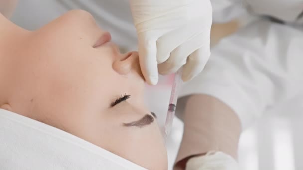 护理时间是当之无愧的 在这段时间里 面部表情平静的妇女通过美容师诊所的专业肉毒杆菌疗法接受了美容手术 垂直录像 — 图库视频影像