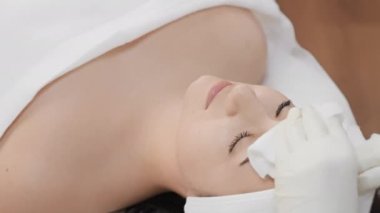 Parlak cilt: kozmetoloji, bir uzmanın, bir kadının yüz temizleme ameliyatından parlak cilt almasına yardım ettiği yüksek bir seviyedir. Spa tedavilerinde rahatlama. Makyaj temizleme. Yüksek kalite 4k görüntü