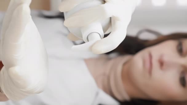 専門の美容師が保湿クリームとスキンケアクリームを手に取り 患者さんの顔への応用を目指しています 迅速かつ効果的な顔の浄化 女性の新鮮さと更新を与えます — ストック動画