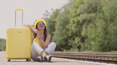 Hayalperest bir kız bavuluna yaslanmış, yolculuk boyunca maceralarını yansıtıyor. Bir kadın, tatillerde gelecekte mutlu bir dinlenme anı hayal eder. İstasyonda nakil için bekliyorlar. Yüksek