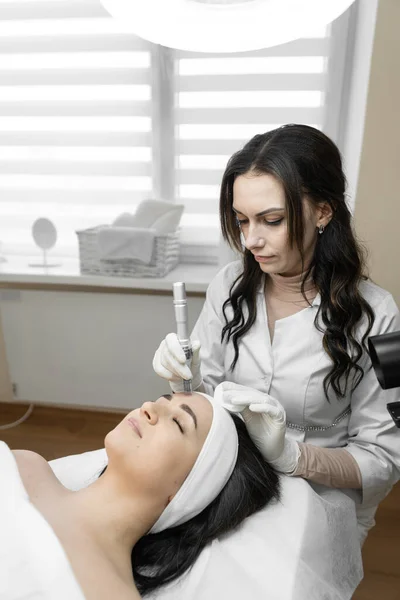 The soothing atmosphere of the beauty clinic creates ideal conditions for fractional facial mesotherapy. Rest, pleasure and relaxation of a young woman in a beauty clinic during skin care. High