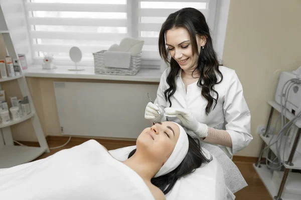 The process of deep cleansing of facial skin is presented, during which a young woman is in a calm and comfortable environment, enjoying professional skin care in a beauty clinic. High quality photo