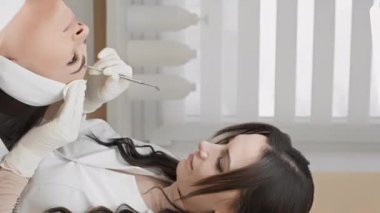 Bir güzellik kliniği sunulur, profesyonel bir kozmetikçi, müşterilerine yeni ve ışıl ışıl bir görünüm kazandırmak için derin bir cilt temizleme seansı düzenler. Dikey video