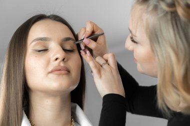 Kaş tasarım ustası doğallık ve dışavurumluluk arasında bir denge bulur, müşterilerin yüzüne cazibe ve çekicilik ekler. Makyöz kaşlarını düzeltiyor. Güzellik uzmanı.