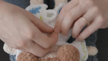 Kız elbisesine iplik bağlanmış bir bebek takıyor. Genç bir kadın bir oyuncakla oynar, onun için bir giyim tarzı seçer. Yüksek kalite 4k görüntü