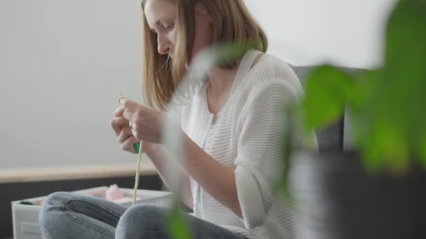 女性はエレガントなAmigurumiを編み 均質なループに糸を織り 子供のお気に入りになる忘れられない織物のおもちゃを作成します 趣味や自宅で休む 高品質4K映像 — ストック動画