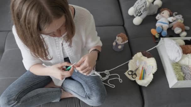 一个有创意的有才华的女工匠会把纱线交织在一起 创造出一种在外观和优雅上接近完美的阿弥陀佛 在家里的沙发上坐着工作 高质量4K — 图库视频影像