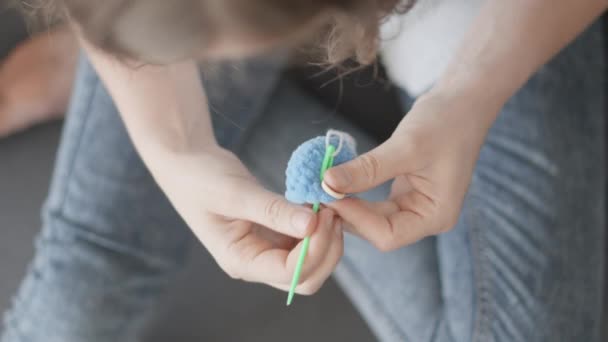 一个有能力编织羊毛衫的女人 很容易操纵线 并把线变成神奇的纺织品玩具来装饰孩子们的房间 为玩具娃娃编织玩具配件 高质量的 — 图库视频影像