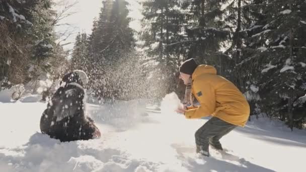 雪の中で喜ぶ男と女が雪玉で遊び 雪を投げ合う カップルの愛は 一緒に自然と幸せな瞬間の重要性を強調し ビデオで明らかにされています — ストック動画