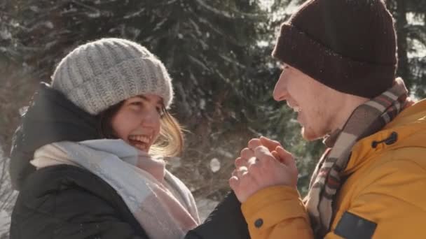 彼らの目の中の幸福は このカップルがリラックスしながら美しい冬の自然を共同で探索するときに気づくことは不可能です 男は女性の手を暖め 彼女といちゃつくし — ストック動画