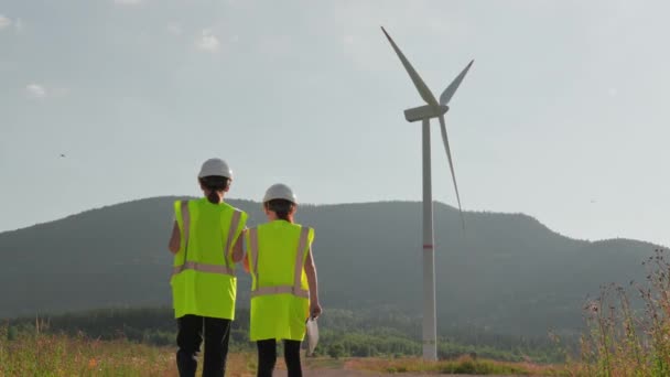 负责任的环境工程师监测风力发电机组的稳定运作 以确保有一个绿色 光明的未来 工人们带着巨大的刀片去了一个巨大的风车 高质量的4K镜头 — 图库视频影像