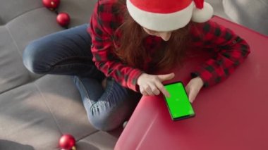 Elinde akıllı telefonu olan komik bir kız kışın, Noel 'de ve yılbaşında tatil planları yapıyor. Çevrimiçi arama ve kalacak yer rezervasyonu. Yeşil ekran ve kromakey