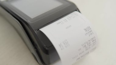 Çek ödemeden sonra POS terminalinden ayrılıyor. Alım ve yerleşim yeri mağazada. Hizmetler için ödeme. Mağazadaki hizmetler için nakit ödemeler. Yüksek kalite 4k görüntü