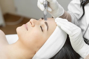 Kısmi mezoterapi süreci cilt bakımını ve yapısını geliştirmeyi sağlar. Güzellik uzmanındaki bir resepsiyonda genç ve güzel bir kadının yüzüne yakın çekim. Yüksek