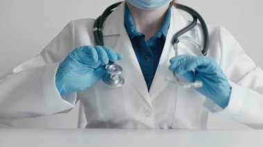 Tıp mesleği: koruyucu eldivenler giymiş kadın doktor ve boynuna steteskop takılmış, klinikte çalışmaya hazır, profesyonel tıbbi bakım ve sağlığın korunmasında yardım. Yüksek kalite 4k