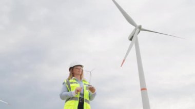 Bir bilim adamı rüzgar enerjisinin parçalanması: bir bilim adamı rüzgar gücünü ve sürdürülebilir elektrik üretme olasılıklarını araştırıyor. Bir kadın uzman rüzgar jeneratörlerinin etkinliğine dikkat çeker.