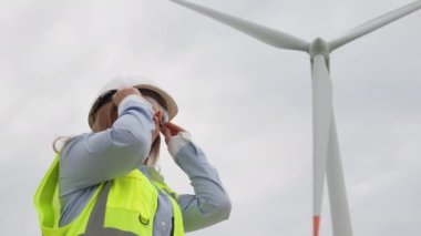 Bir kadın ekolojist yeşil enerji geliştirir: bir bilim adamı rüzgarı elektriğe dönüştürmek için bir istasyon yaratma olasılığını araştırır. Rüzgar koruma yaklaşımı: mühendis bir plan üzerinde çalışıyor