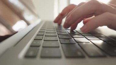 Bir kadın verimli bir şekilde çalışmak için klavyeyi kullanarak dizüstü bilgisayara odaklanıyor. İşçi dizüstü bilgisayarı üzerinde derinlemesine çalışıyor, hedeflerine ulaşmak için teknolojiyi kullanıyor. Yüksek kalite 4k görüntü