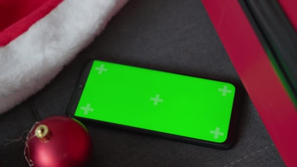 クリスマスと新年の魔法の雰囲気とオンラインストアとインターネットサービスとウェブサイトで必要なすべてのギフトやサービス クロマキー効果のための緑色の電話スクリーン — ストック動画