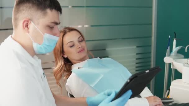 患者は相談中に口腔の状態について明確な情報を得る 歯科医は 歯の診断と治療に対する専門的なアプローチを示しています — ストック動画