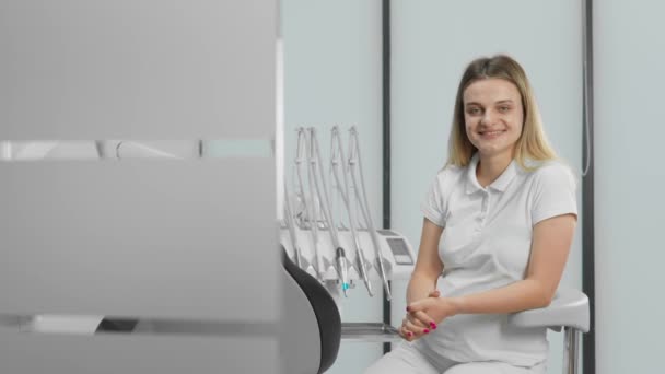 Dentysta Siedzący Patrzący Kamerę Klinika Stomatologiczna Działa Nowoczesnym Sprzęcie Pozwala — Wideo stockowe