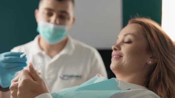 牙医向病人解释了用假牙矫正咬伤的原理 病人在牙科诊所接受关于使用假牙的专业咨询 高质量的4K镜头 — 图库视频影像