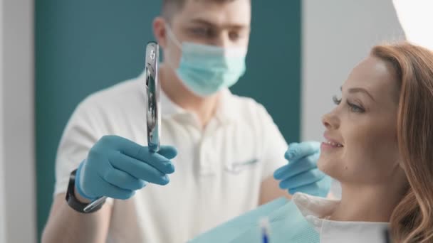 Ασθενής Εξετάζει Προσεκτικά Δόντια Και Ούλα Της Στον Καθρέφτη Κατά — Αρχείο Βίντεο