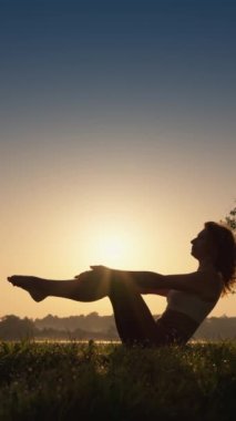 Sabah meditasyonu ve göl yogası enerji ve denge sağlar. Dikey video biçimi. Fiziksel aktivite ve açık hava yogası gündoğumunda sağlığa yardımcı olur. Yüksek kaliteli FullHD görüntüler