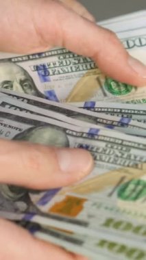 Bir grup banknot, finansal zenginlik ve iş ve yatırım için büyük fırsatlar izlenimi veriyor. Adam banknotları dikkatle sayıyor, mali durumları idare etme yeteneğini yansıtıyor ve...