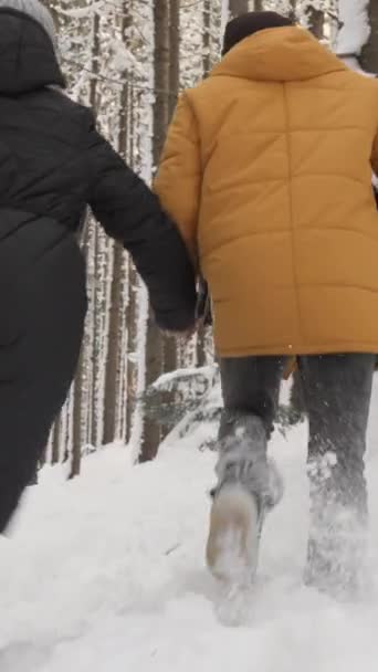 Чоловік Жінка Бігають Через Зимовий Ліс Сніг Тримаючись Руки Відволікаючись — стокове відео