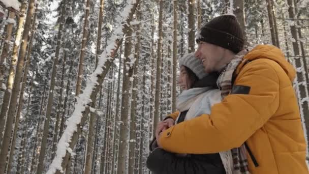 寒冷的冬季森林创造了一种宁静的氛围 在这种氛围中 年轻夫妇找到了和谐与和谐 冬天在森林里散步的时候抱着他女朋友的家伙 — 图库视频影像