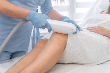 Pürüzsüz pürüzsüz cildin sırrını keşfedin. Güzellik ve güzelliği takdir eden bir kadın için güzellik kliniğinde güzellik uzmanının lazer fotoepilasyon prosedürünü gösterdiği yerde. Öz