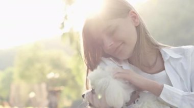 Bağlılık ve neşe: Maltalı süs köpeği ve metresi günü birlikte geçirirler, birbirlerine gülümseyerek. Doğada arkadaşlık: Parkta, bir kadın ve köpeği eğlenerek zaman geçirir ve
