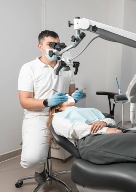 Bir dişçi hastaların dişlerini doğru ve profesyonelce tedavi etmek için mikroskop kullanır. Diş tedavisi prosedürü bir doktorun gözetiminde ve daha yüksek verimlilik için mikroskop altında. Yüksek kalite