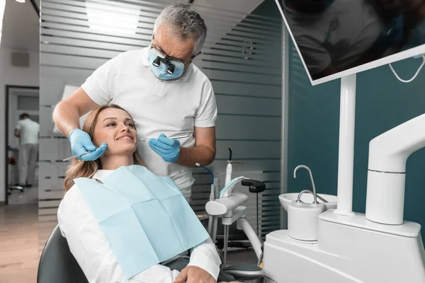 In the dental clinic, dental implants are installed to restore the patients smile. The dentist provides advice to the patient on oral care and dental health. High quality photo