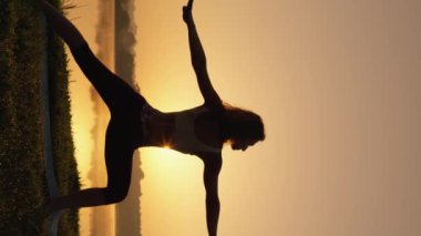 İç uyum ve güç için kadın ve sabah yogası. Yoga doğada rahatlama ve kendini geliştirme amaçlıdır. Yoga ve Meditasyon yoluyla Doğayla Toplumu Vurgulayan Dikey Gündoğumu Videosu. Yüksek